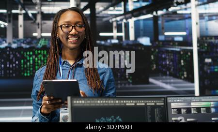 Portrait of upbeat server hub software developer using node tree software to optimize system health. Radiant data center staff member analyzing rigs issues using AI visualization, camera B Stock Photo