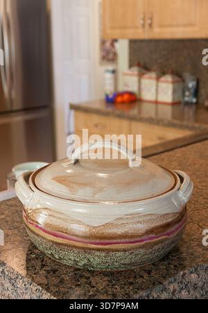 A ceramic casserole dish sitting on a kitchen countertop. Stock Photo