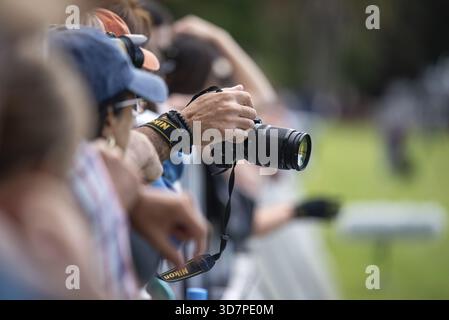 A man's hand holds a Nikon DSLR camera during a sporting event in Buenos Aires, Argentina Stock Photo