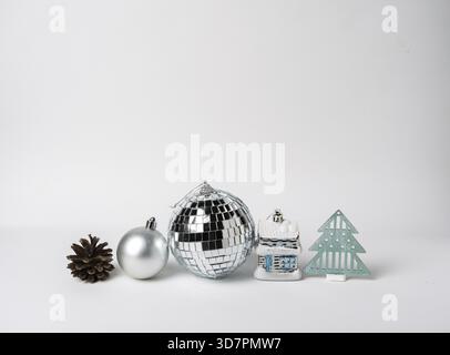 Silver disco ball, Christmas tree decorations, pine cone on a white background, Christmas decor, space for text Stock Photo
