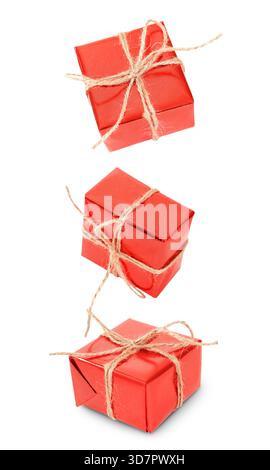 Three red gift boxes wrapped with rustic twine and bows, floating or falling, isolated on a white/transparent background. High quality photo Stock Photo