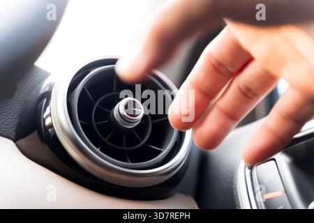 Close-up shot of a hand adjusting the air vent inside a modern car interior, highlighting airflow control, comfort, and temperature adjustment details Stock Photo