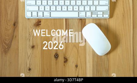 Welcome 2026, next to computer mouse and keyboard. Top view. Stock Photo