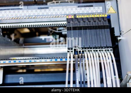 Close view of surface mount pick and place machine with electronic component tape feeders in modern automated assembly plant Stock Photo