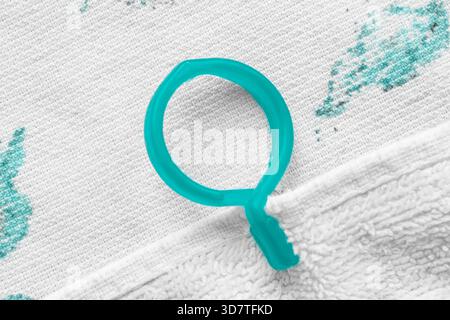 Plastic blue clothespin put on white terry towel closeup Stock Photo