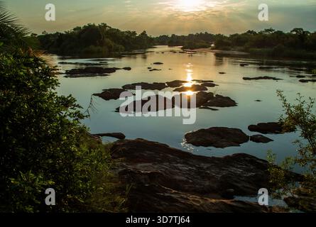 The low sun reflecting through the black rocks below the Popa Falls on the Kavango River Stock Photo