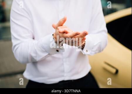 A man in a white shirt rubs his hands. High quality photo Stock Photo