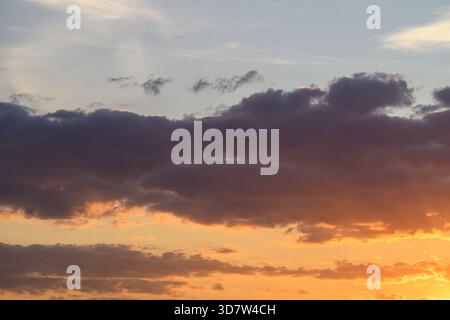 Soft pastel cloudscape at sunset, muted peach and lavender tones, wispy high clouds, tranquil atmosphere, minimal composition, ideal for wellness and Stock Photo