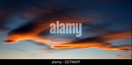 Vivid sunset sky with dramatic clouds illuminated in orange and red hues. Calgary, Canada Stock Photo