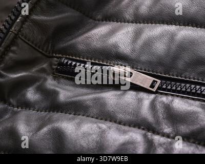 Close-up of a black leather jacket with a metallic zipper detail. Stock Photo