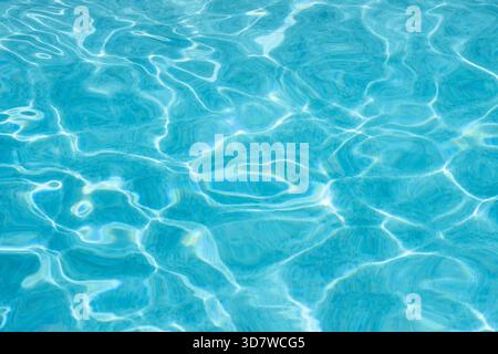 Light blue water reflecting sunlight in swimming pool Stock Photo