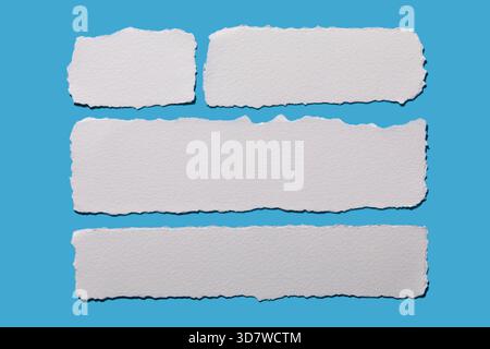 Strips of white torn paper on blue background Stock Photo