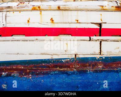Close-up of side of old red white and blue fishing boat Stock Photo