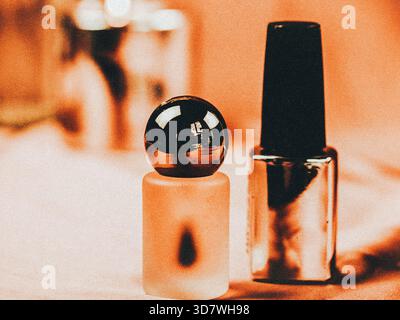 Close-up of nail polish bottles on a soft, textured surface. Two bottles of nail polish are displayed in a warm light, beauty and fashion concepts.  Stock Photo