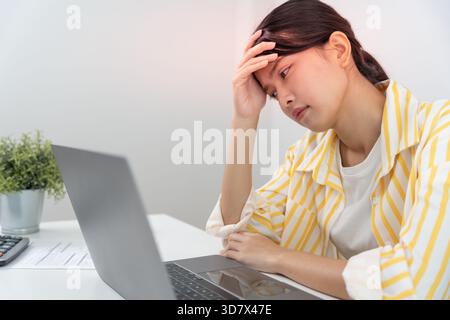 Headache, female having migraine pain, bad health, Asian woman feeling stress and headache, Office syndrome, sad tired touching forehead having migrai Stock Photo