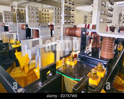 A black box with a yellow cover. The box is made of metal. There are wires and bolts on the box Stock Photo
