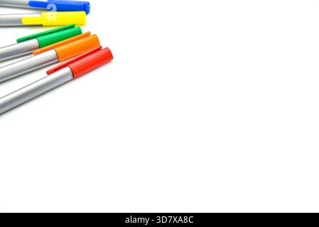 A row of pens with different colors. The pens are lined up on a white background. The pens are of different colors, including red, blue, and green Stock Photo