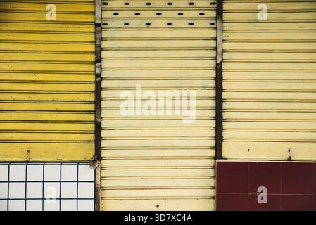 Three doors, one yellow and two red, with white trim Stock Photo