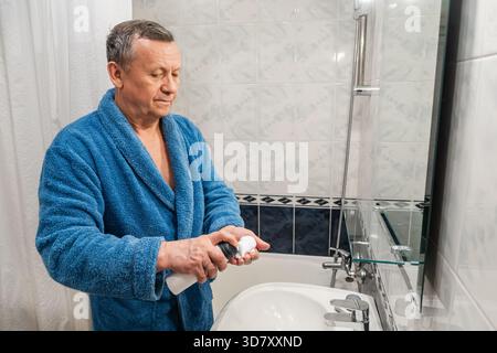 Mature man applying shaving cream in bathroom. Morning Shaving Routine Stock Photo