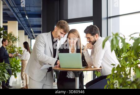 Smiling friendly helpful colleagues working young diverse businesspeople at desk brainstorm, discuss Stock Photo