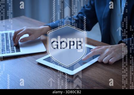 General Data Protection Regulation. Woman using tablet computer and laptop, closeup. Virtual shield with GDPR abbreviation. Privacy security Stock Photo