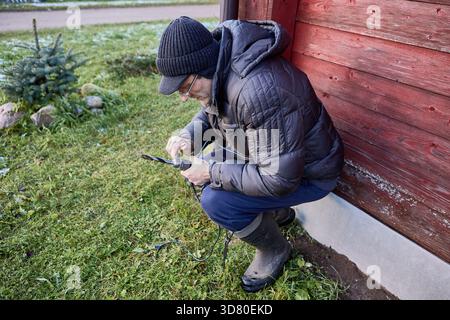 Before carrying out external installation work, repairman secures drill bit using chuck key. Stock Photo
