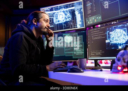 Hacker installing spyware with artificial intelligence to secretly gather data about user activity. Rogue engineer coding exploits using machine learning to gain unauthorized access Stock Photo