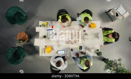 Top down view of architects and engineers collaborating on housing and city planning. Teamwork, innovation and design as real estate experts plan residential project development. Stock Photo