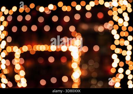 Warm abstract bokeh lights in soft orange tones on black background. Stock Photo