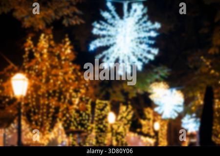 Defocused Christmas lights. Illuminated decorations at the Christmas market at night, blurred background. Stock Photo