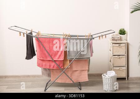 Clean towels hanging on dryer in laundry room Stock Photo