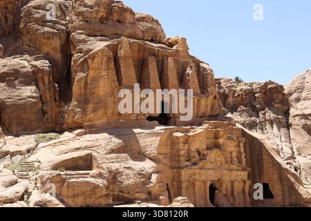Iconic Nabataean rock-hewn tombs carved high into the dramatic rose-red sandstone cliffs of Petra, Jordan. Stock Photo