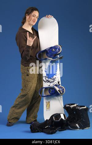 Portrait of a woman with long curly hair with snowboard making the hang loose sign Stock Photo