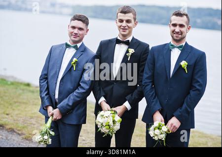 Three friends, groom with groomsman having fun, male potency theme Stock Photo
