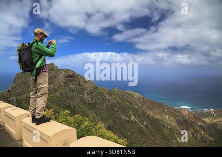 A tourist man taking the landscape photograph using his mobile smartphone Stock Photo