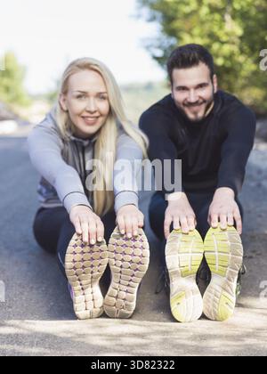 Young health couple doing stretching exercise relaxing and warm up after jogging and running in park Stock Photo
