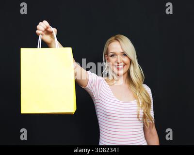 Blonde girl with shopping bags on a chalkboard background Stock Photo