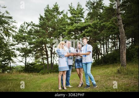 Happy family on pine forest holding cones at hand Stock Photo