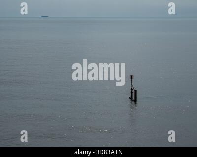 Navigation marker and distant ship on open water Stock Photo