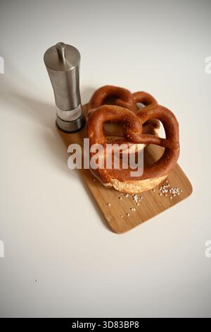 Clean Studio Shot: Two German Pretzels with Salt Shaker on White Background Stock Photo