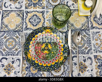 Vibrantly colored plate with mandala pattern set on tablecloth Stock Photo