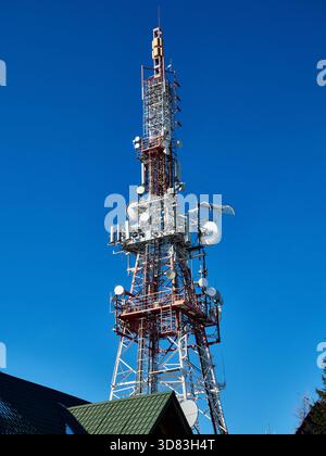 Tall Telecommunication and Broadcasting Tower on a Snowy Mountain Peak Stock Photo