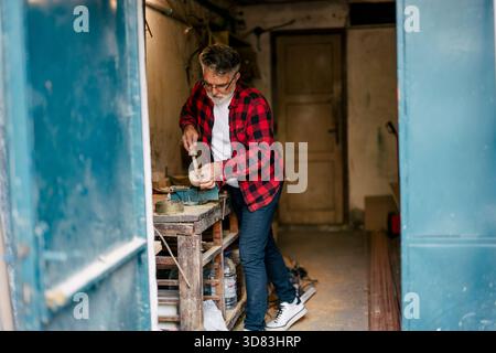 Craftsman working on a wooden project in a workshop Stock Photo