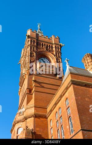 Detail of the Victorian Pierhead Building in Cardiff Bay. An iconic red brick Gothic revival building, known as the Welsh Big Ben, against a clear blu Stock Photo