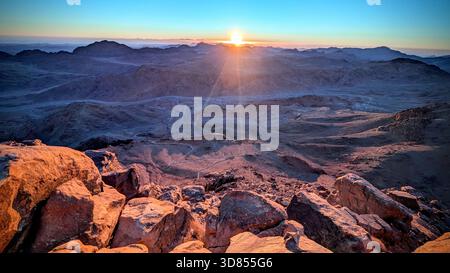 Dawn light over the red mountains of Mount Sinai, capturing the silent beauty of the desert peaks during the ascent to Moses’ Mountain Stock Photo
