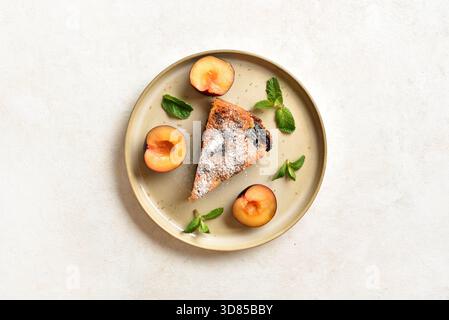 Delicious autumn homemade plum pie on plate on light background. Top view, flat lay. Stock Photo