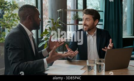 Two multiracial businessmen business team with laptop talking men salesman agent consult male client investor office partners diversity workers Stock Photo