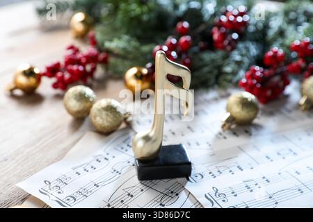 Golden music note, sheets and Christmas decor on table, closeup Stock Photo