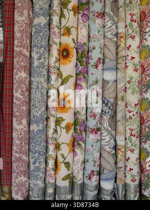 THESSALONIKI, GREECE - MAY 10, 2025 - Colorful fabric rolls featuring botanical prints arranged neatly on display, presenting textile design selection Stock Photo