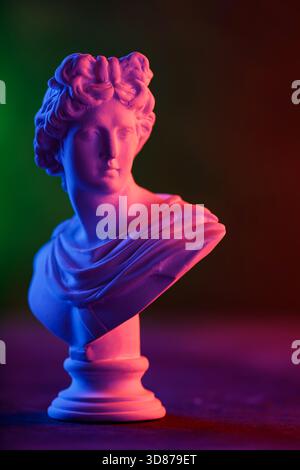 Antique Sculpture Head in Moody Neon Gradient Light Composition Stock Photo